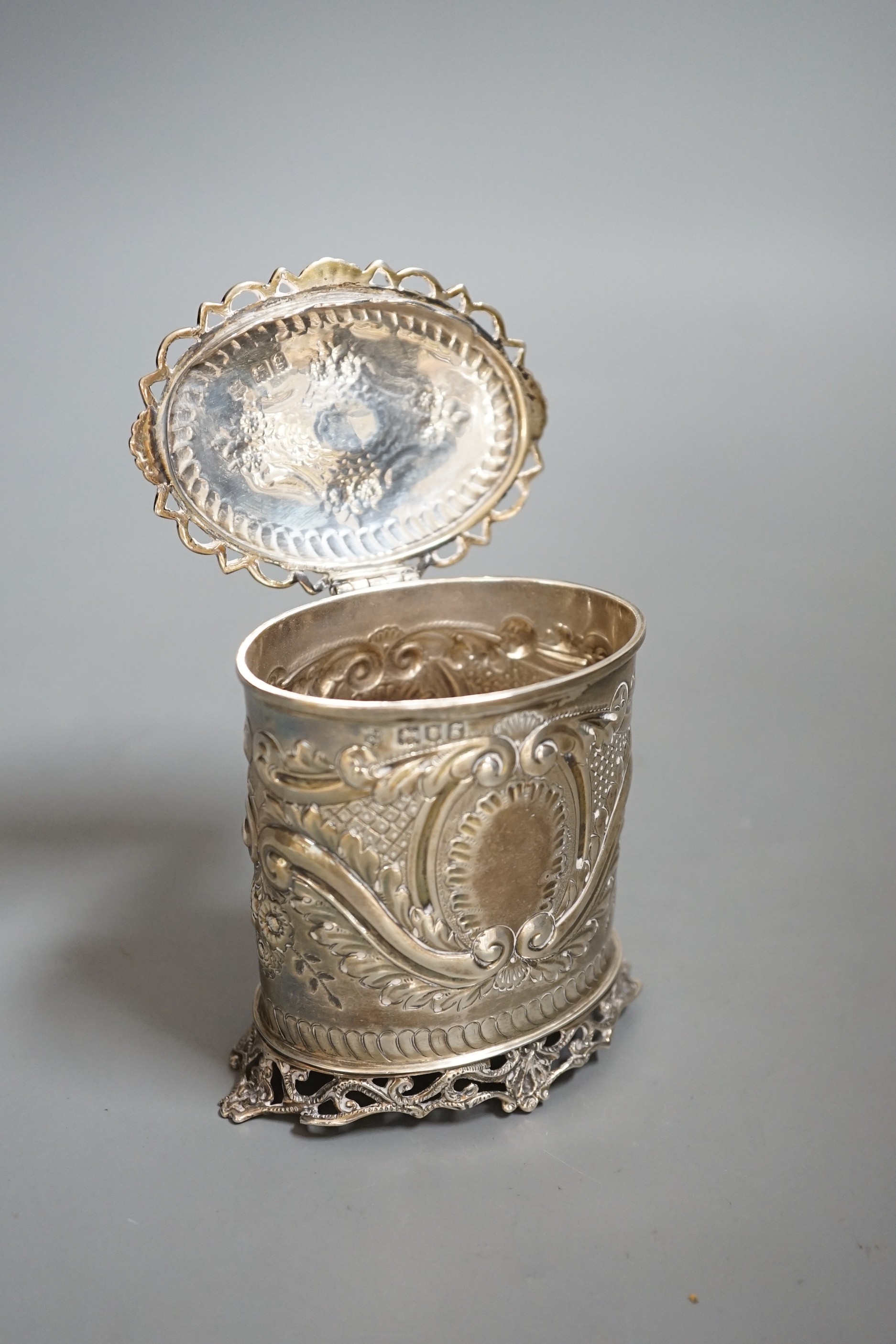 An Edwardian repousse silver oval tea caddy, with pierced borders, Josiah Williams & Co, London, 1902, height 10.2cm, 150 grams.